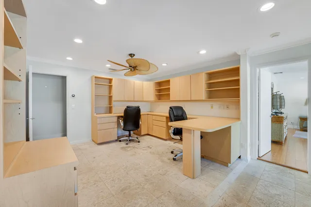 a view of a workspace with furniture and a window