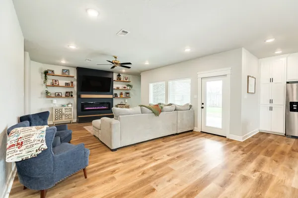 a kitchen with stainless steel appliances kitchen island granite countertop a dining table chairs and refrigerator