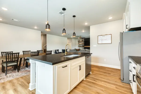a kitchen with stainless steel appliances granite countertop a sink a stove and a wooden floors