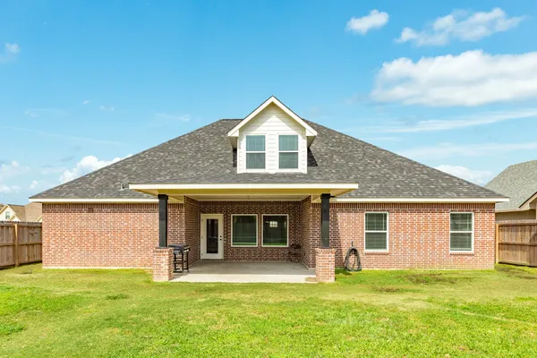 a front view of a house with a garden and yard