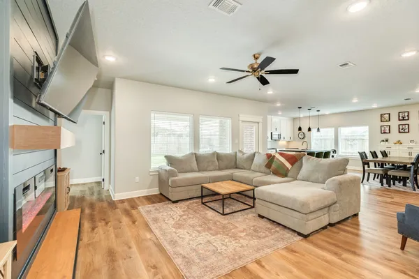 a living room with furniture a ceiling fan and a rug