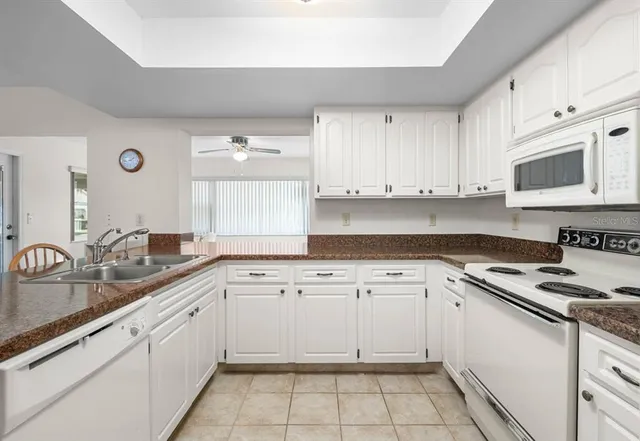 a kitchen with cabinets appliances a sink and a counter top space
