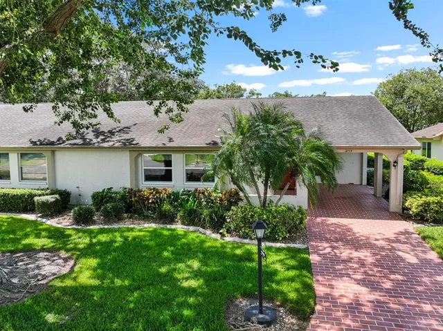a front view of a house with a garden and plants