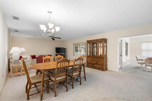 a dining room with furniture a chandelier and window