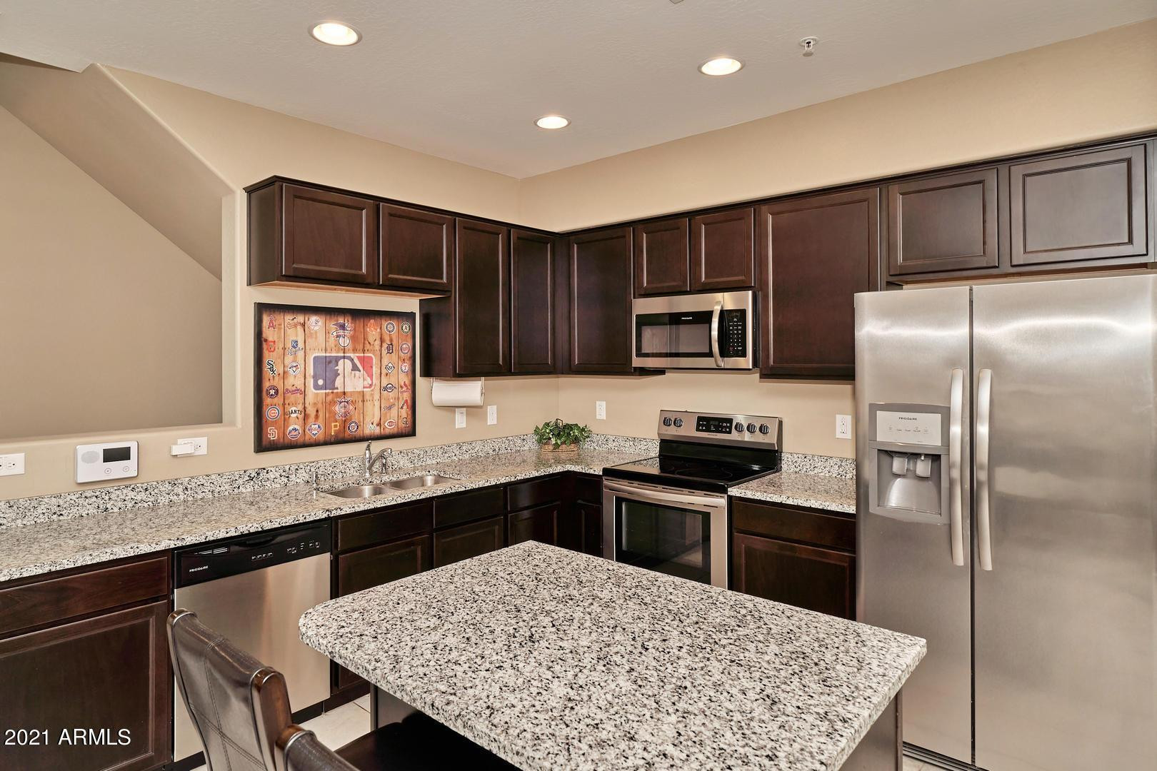 240 West Juniper Avenue, Unit 1089 Gilbert, AZ 85233 - Photo 3 of 24 a kitchen with stainless steel appliances granite countertop a sink refrigerator stove microwave and cabinets