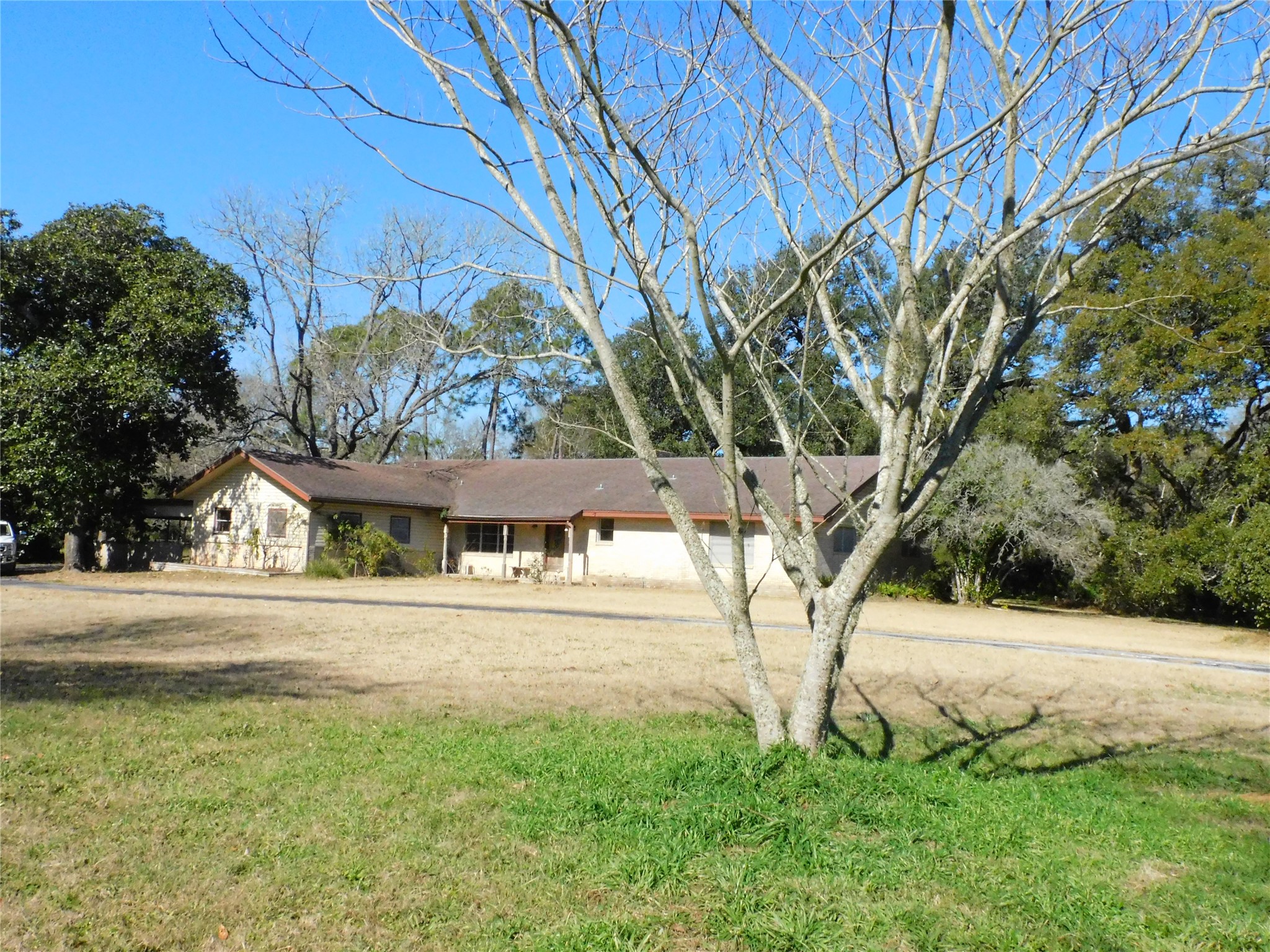 2408 Gun And Rod Road Brenham, TX 77833 - Photo 5 of 16 a view of a white house with a big yard and large trees
