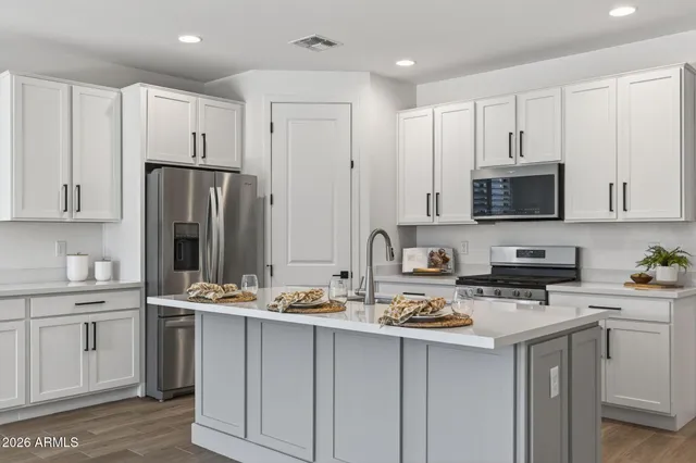 a kitchen with stainless steel appliances a stove refrigerator sink and microwave