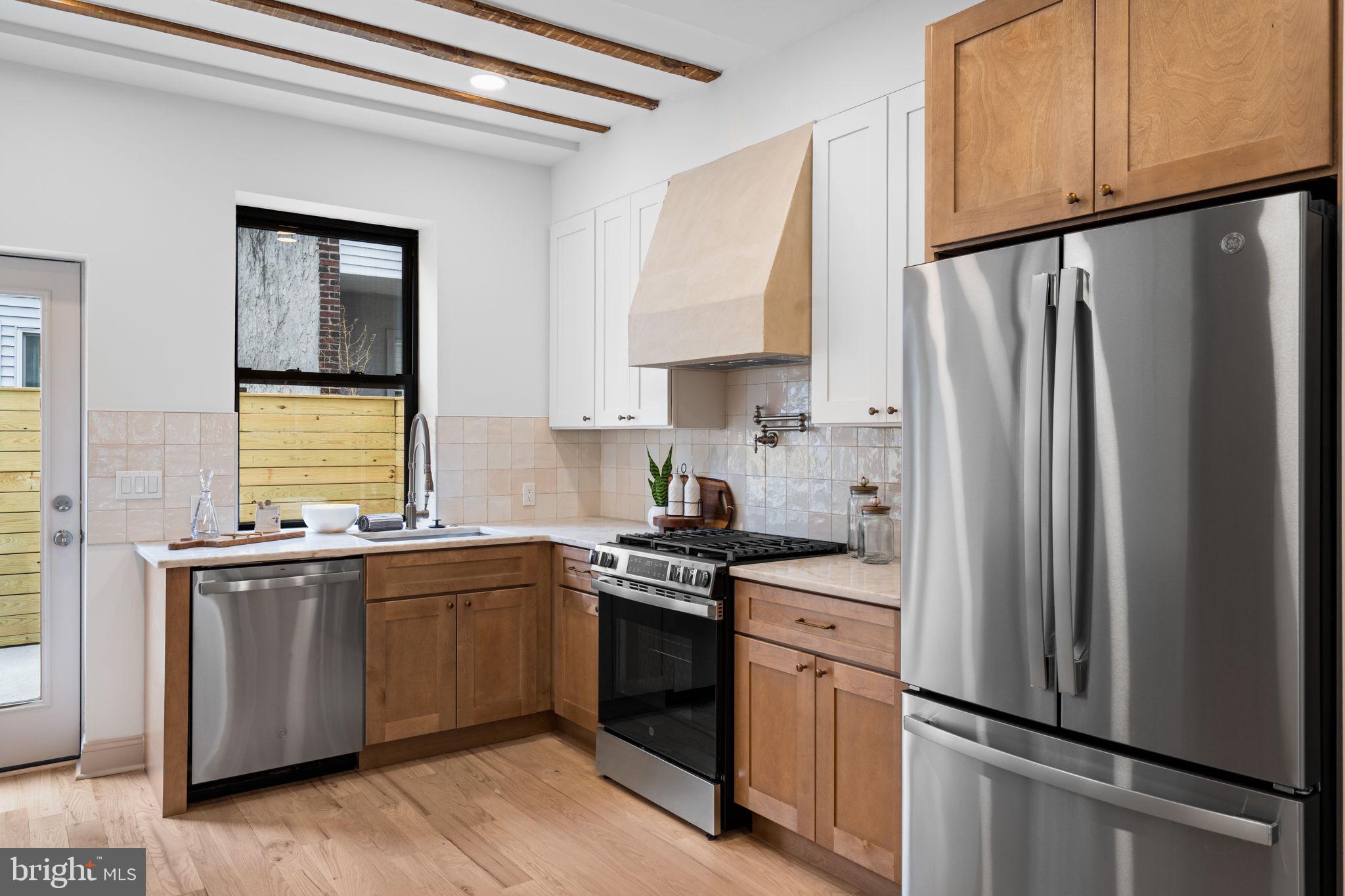 404 Pierce Street Philadelphia, PA 19148 - Photo 12 of 31 a kitchen with stainless steel appliances a sink cabinets and a window