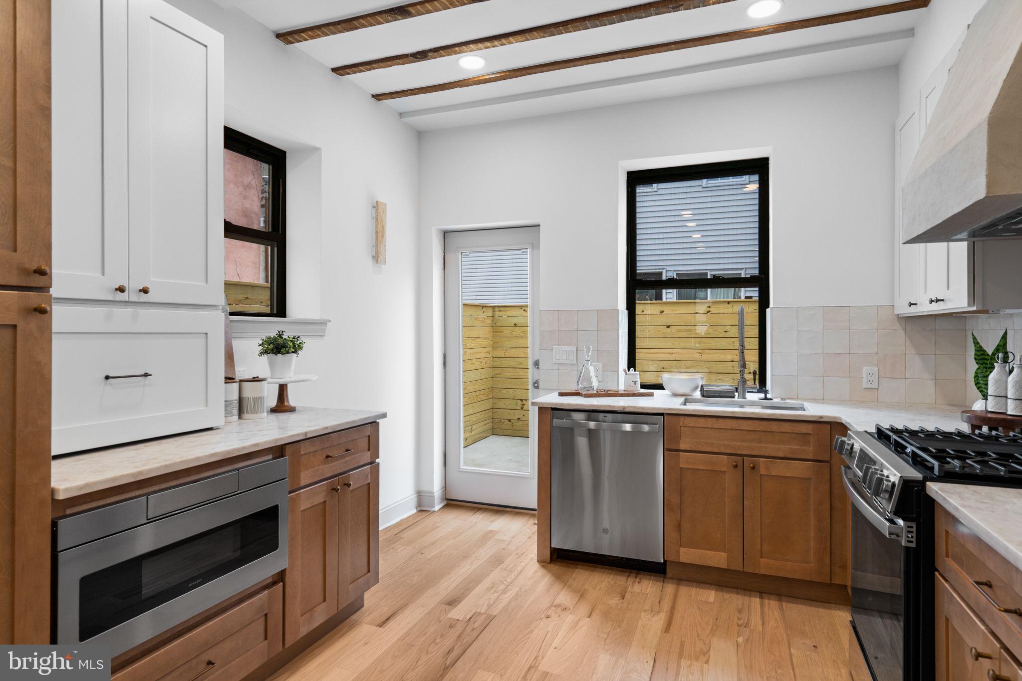 404 Pierce Street Philadelphia, PA 19148 - Photo 13 of 31 a kitchen with stainless steel appliances a stove cabinets and wooden floor
