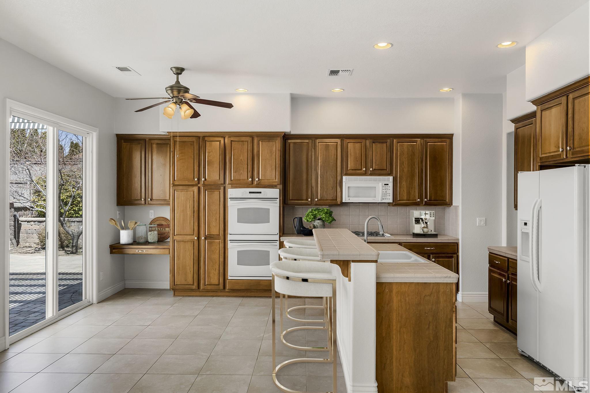 8115 Fire Opal Lane Reno, NV 89506 - Photo 13 of 40 a kitchen that has a lot of cabinets stainless steel appliances and a window