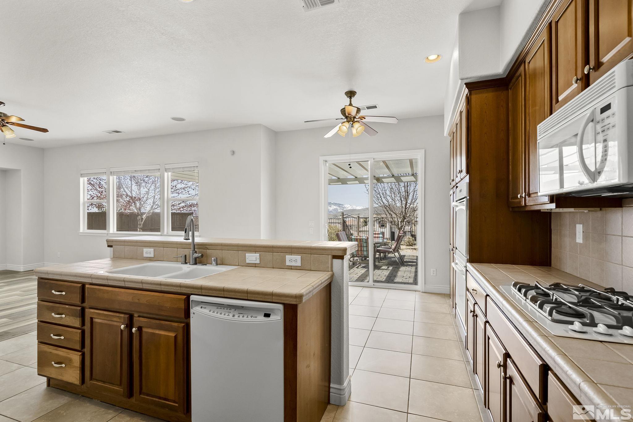 8115 Fire Opal Lane Reno, NV 89506 - Photo 15 of 40 a kitchen with a stove a sink and a refrigerator