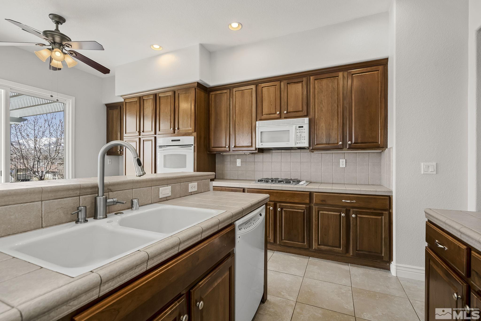 8115 Fire Opal Lane Reno, NV 89506 - Photo 16 of 40 a kitchen with a sink stove and cabinets