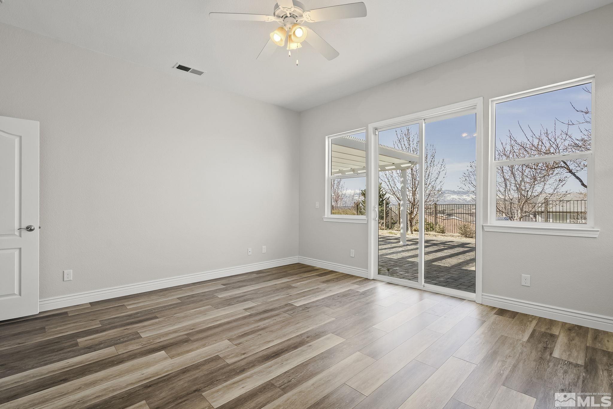 8115 Fire Opal Lane Reno, NV 89506 - Photo 18 of 40 wooden floor in an empty room with a window