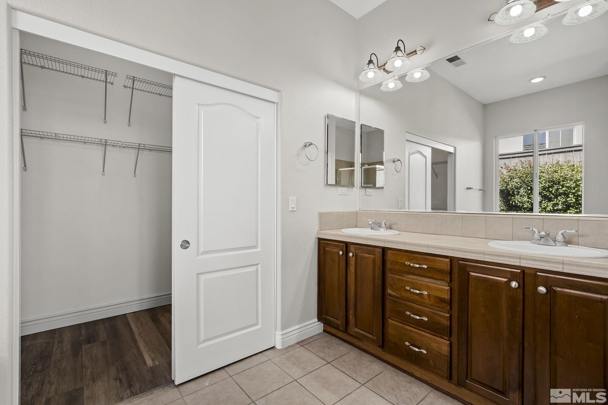 8115 Fire Opal Lane Reno, NV 89506 - Photo 19 of 40 a spacious bathroom with a granite countertop sink a mirror and a vanity