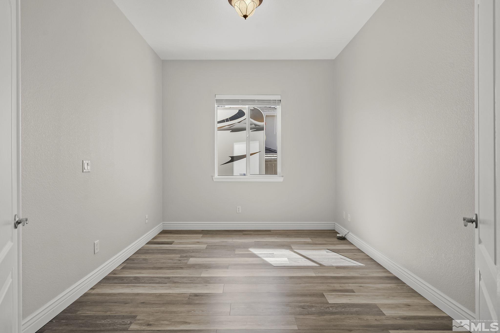 8115 Fire Opal Lane Reno, NV 89506 - Photo 25 of 40 an empty room with wooden floor and windows