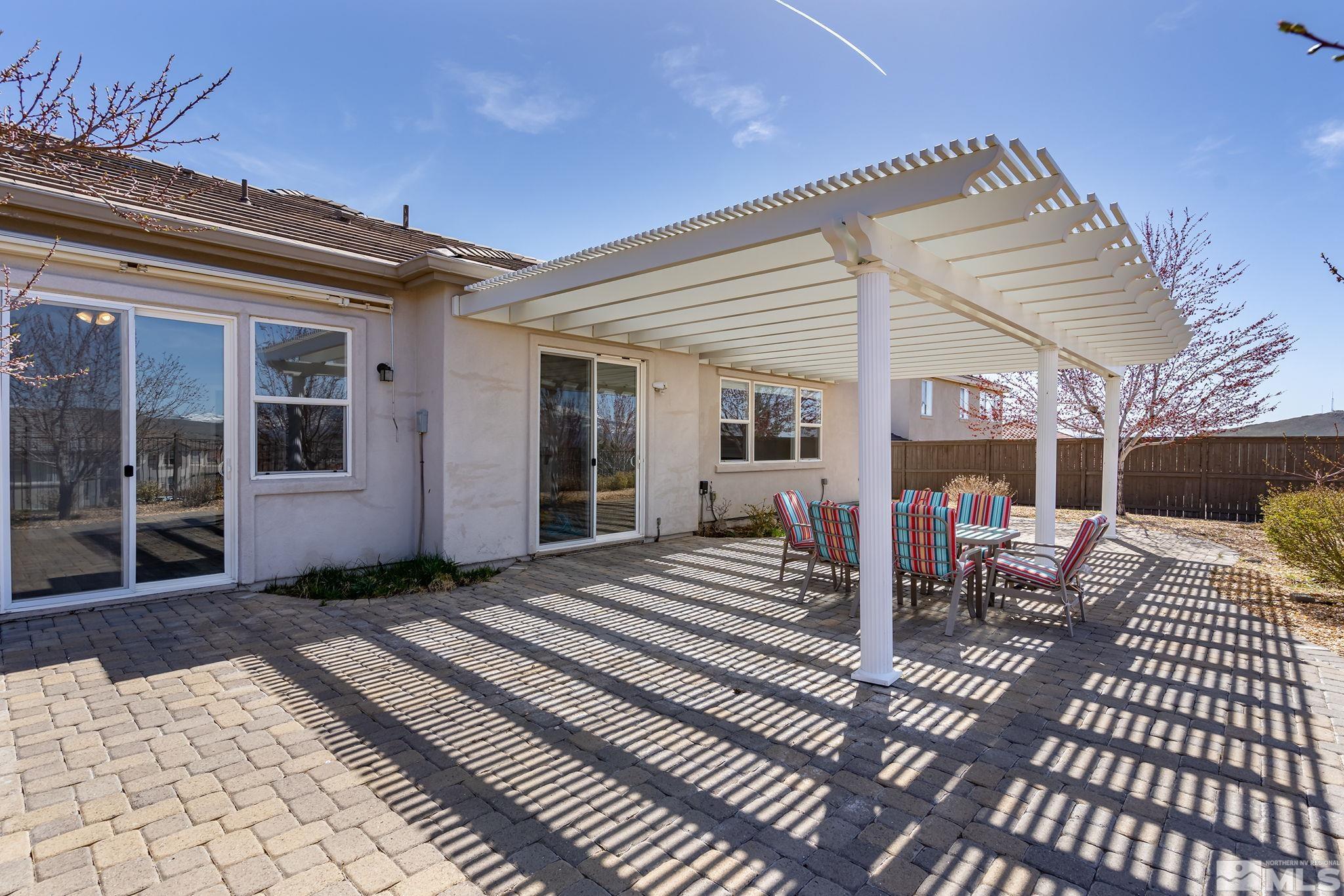 8115 Fire Opal Lane Reno, NV 89506 - Photo 29 of 40 a view of a patio with table and chairs with wooden floor and fence