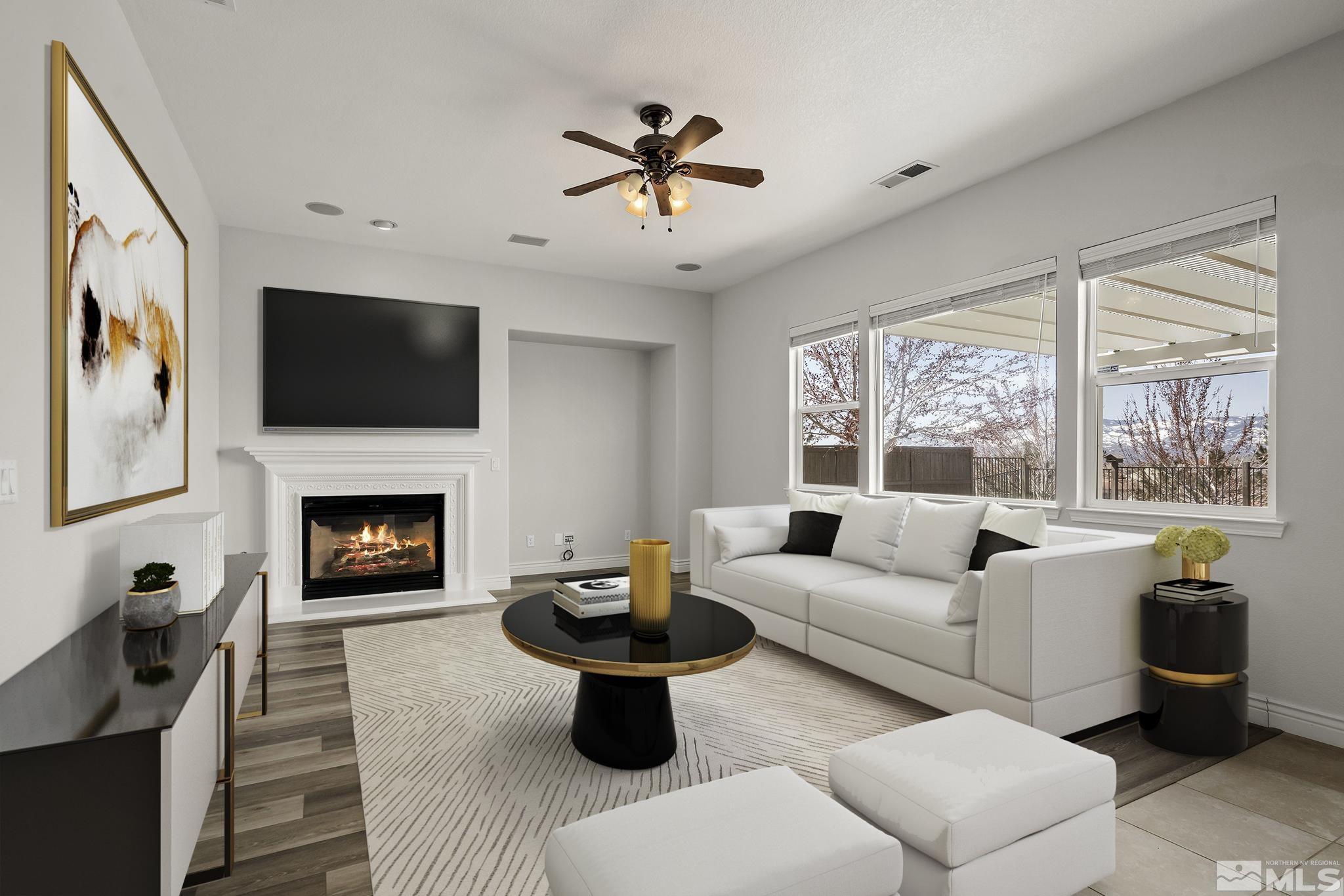 8115 Fire Opal Lane Reno, NV 89506 - Photo 4 of 40 a living room with furniture a flat screen tv and a fireplace