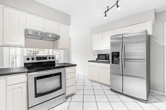 a kitchen with a stove top oven and refrigerator