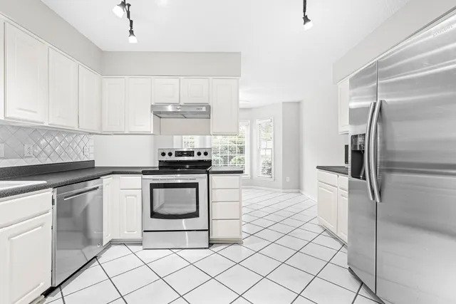 a kitchen with a refrigerator sink and cabinets