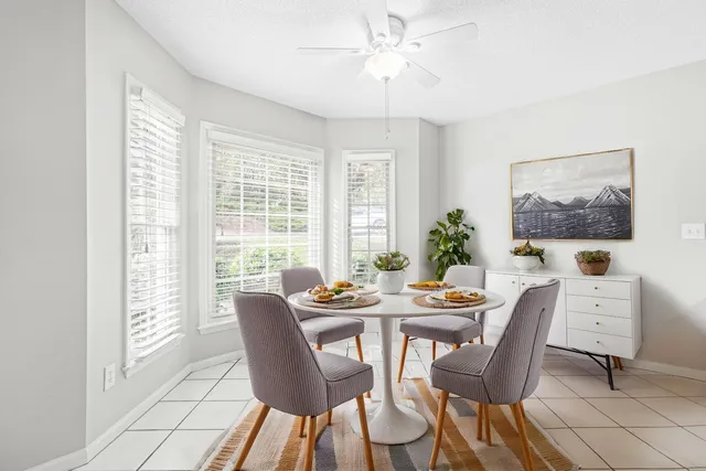 a dining room with furniture a large window and a chandelier