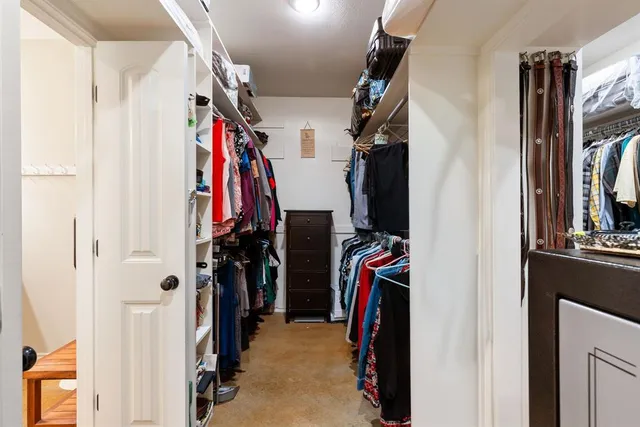 a view of walk in closet with clothes
