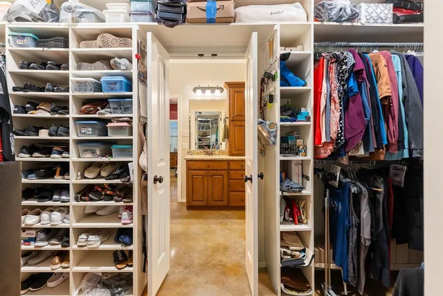 a view of walk in closet with clothes and shoes