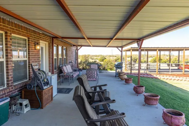a view of a patio with chairs and floor to ceiling window
