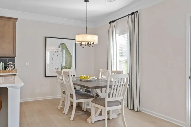 a kitchen with stainless steel appliances granite countertop a stove a sink a microwave a refrigerator white cabinets and chairs