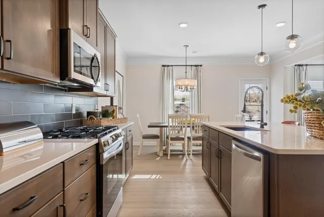 a kitchen with stainless steel appliances kitchen island granite countertop a sink and a refrigerator