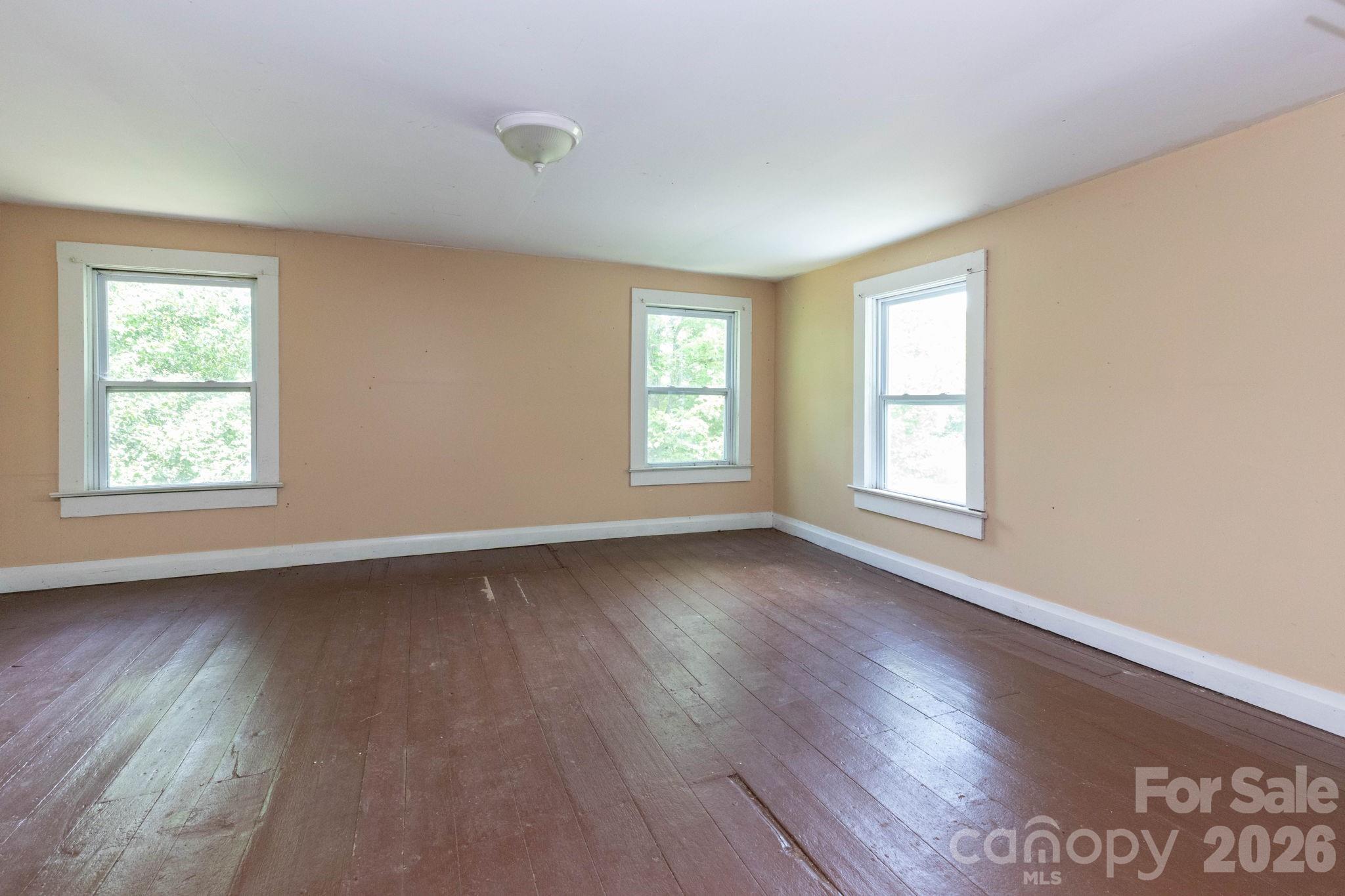 4085 Jacks Creek Road Burnsville, NC 28714 - Photo 19 of 24 a view of an empty room with wooden floor and window