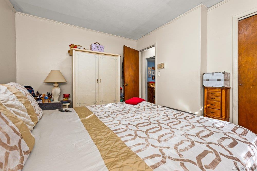 145-95 221st Street Queens, NY 11413 - Photo 19 of 38 a bedroom with a bed and a mirror