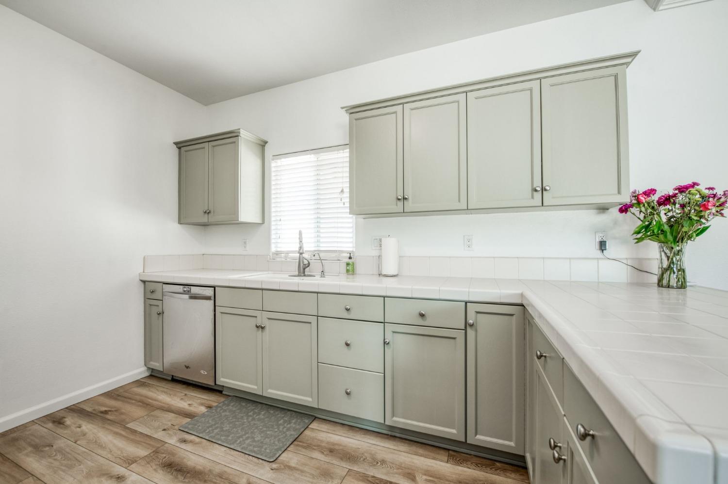 6980 Chaparral Drive Sanger, CA 93657 - Photo 26 of 41 a kitchen with sink cabinets and wooden floor