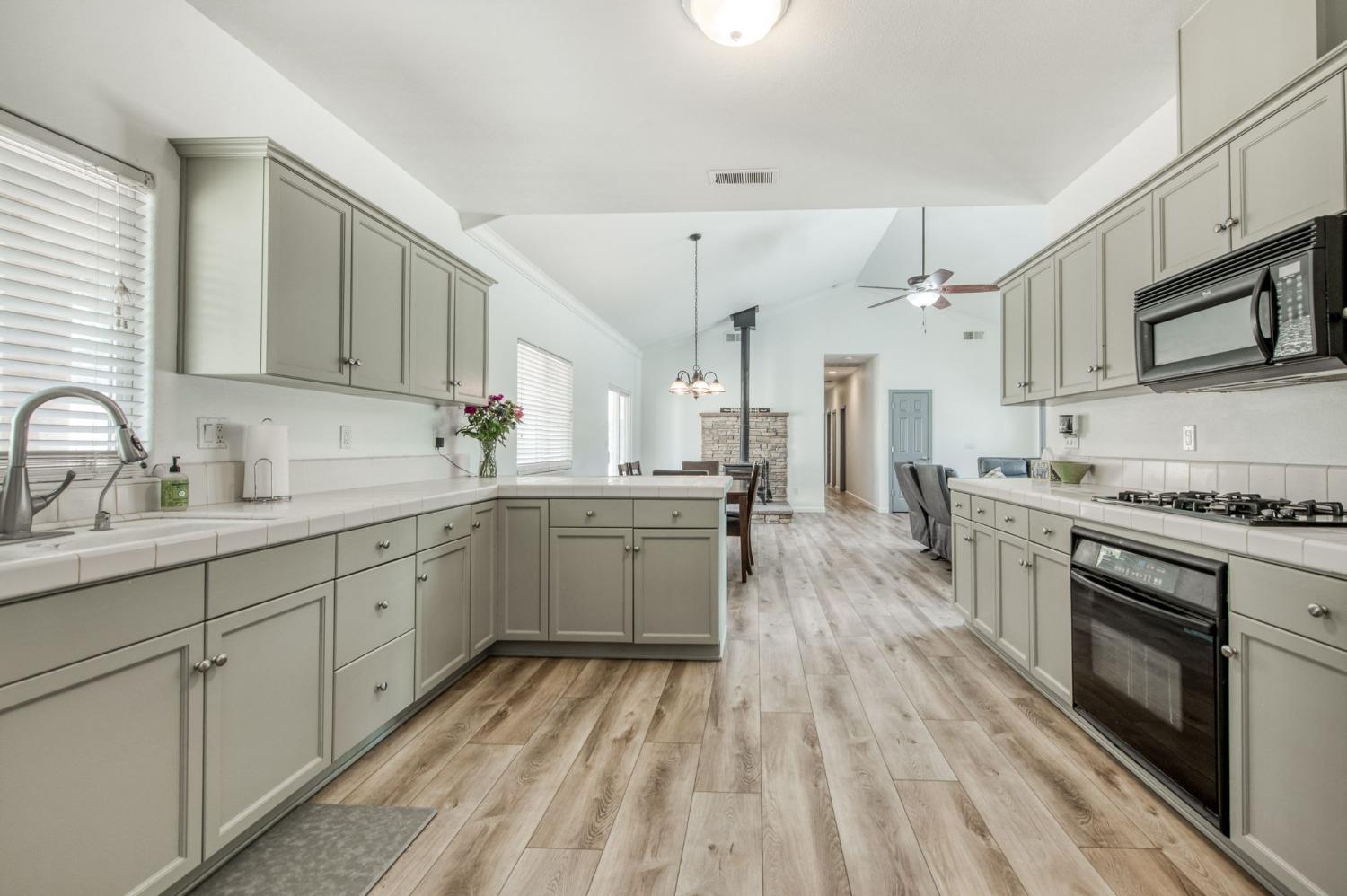 6980 Chaparral Drive Sanger, CA 93657 - Photo 28 of 41 a kitchen with stainless steel appliances sink stove refrigerator and cabinets