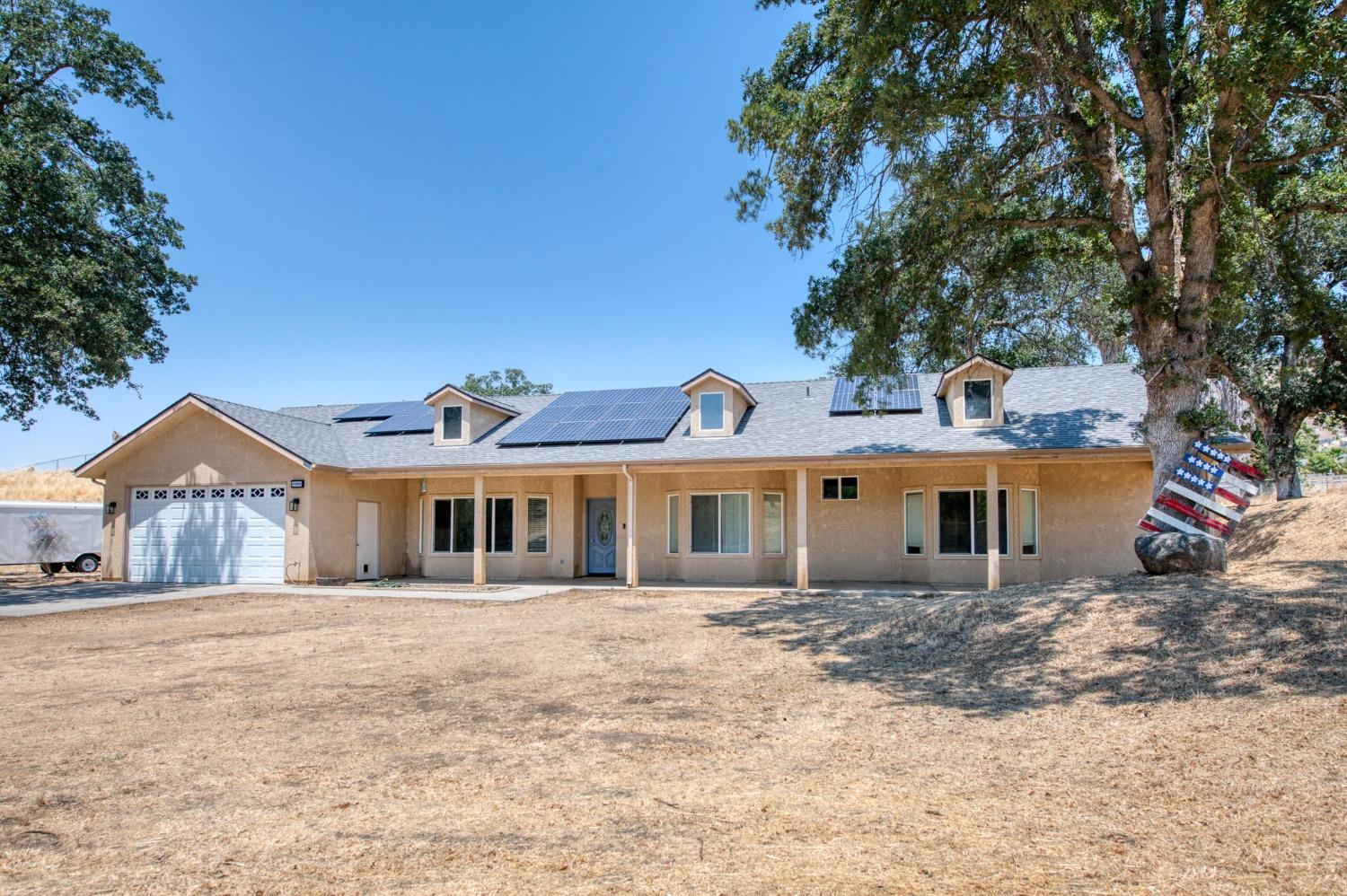 6980 Chaparral Drive Sanger, CA 93657 - Photo 3 of 41 a view of a white house with a large tree in front of it