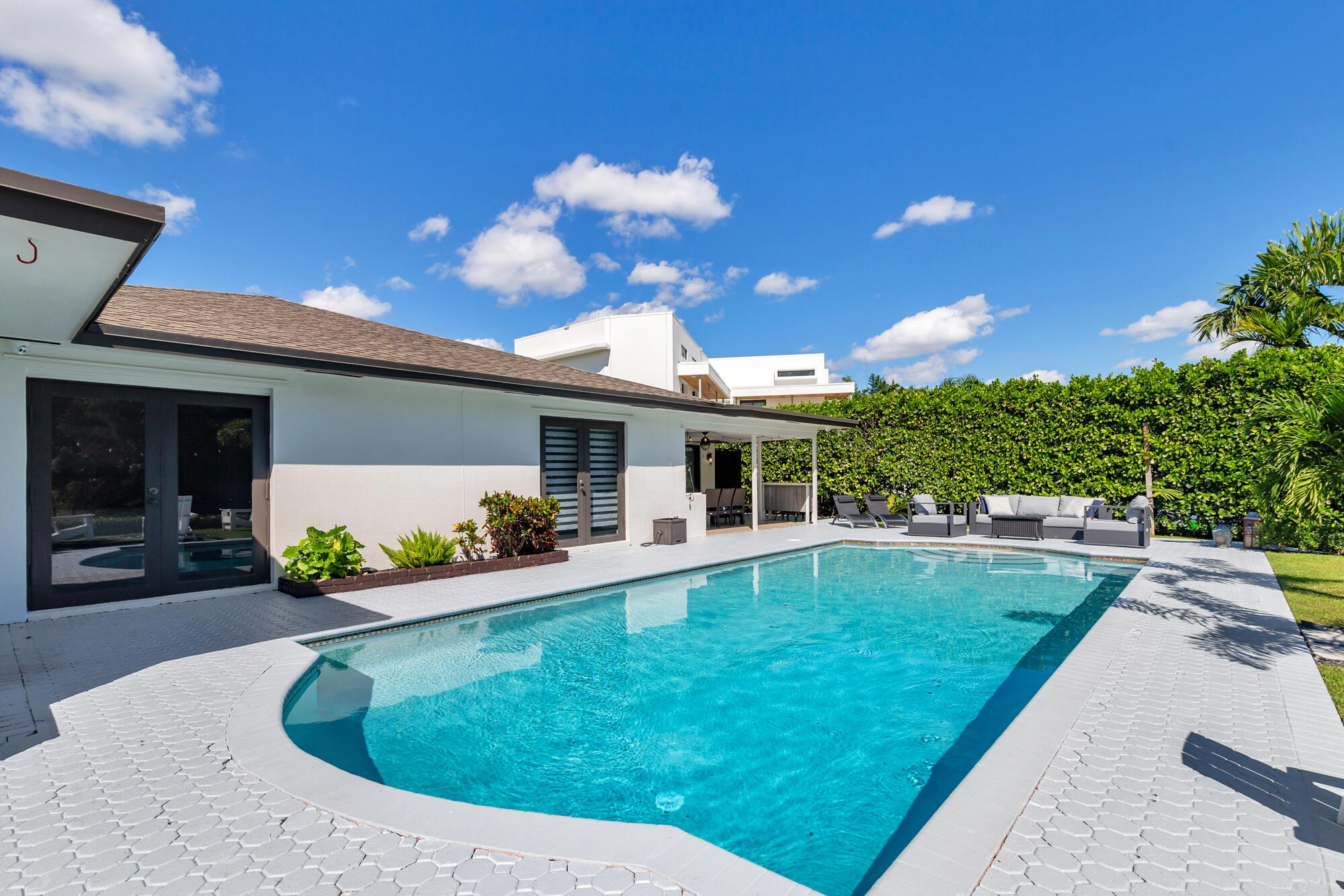 7730 Beta Circle Lake Clarke Shores, FL 33406 - Photo 14 of 50 a view of a house with backyard sitting area and swimming pool