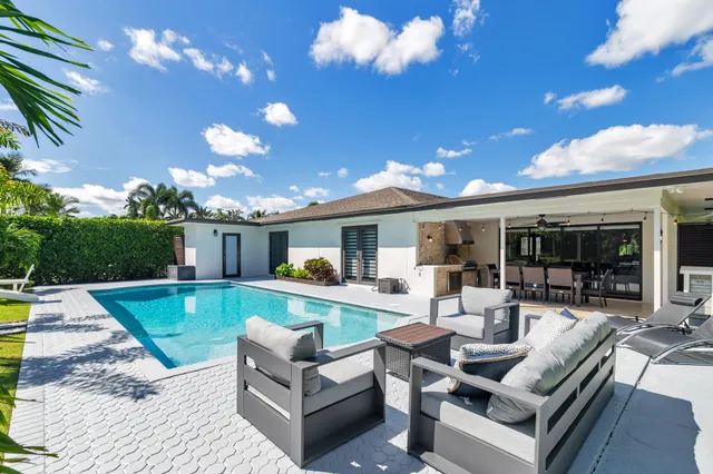 a view of a house with swimming pool and sitting area