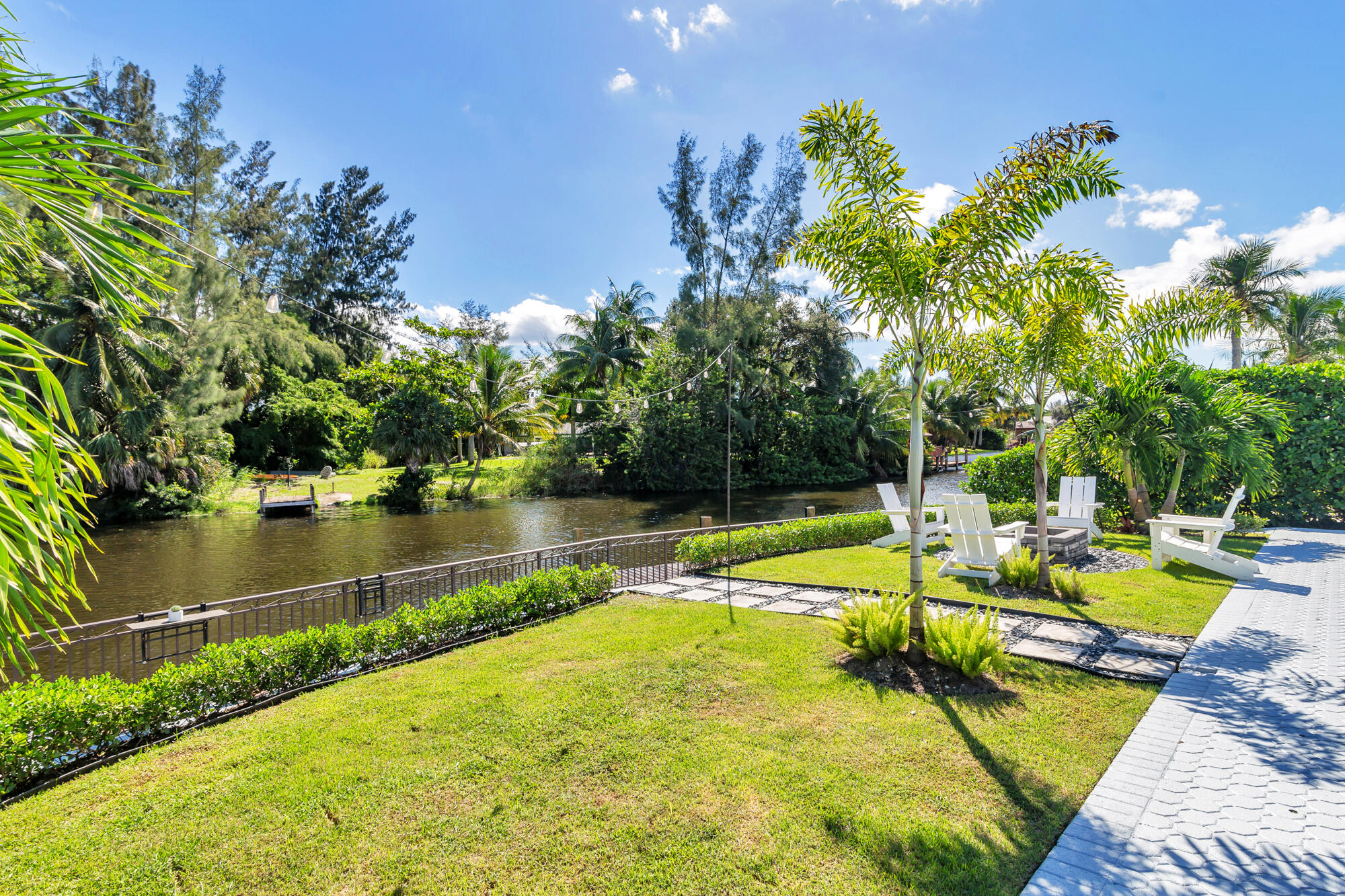7730 Beta Circle Lake Clarke Shores, FL 33406 - Photo 19 of 50 a view of a swimming pool with a bench and trees around