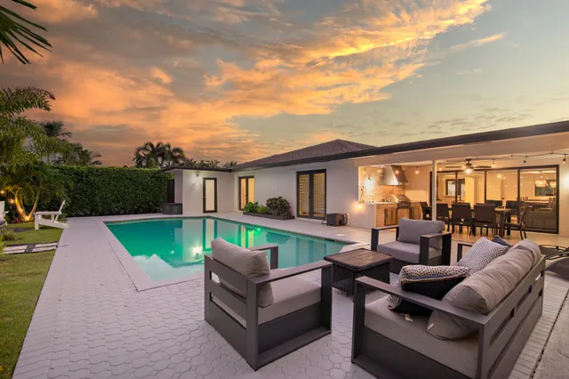 a patio with swimming pool table and chairs