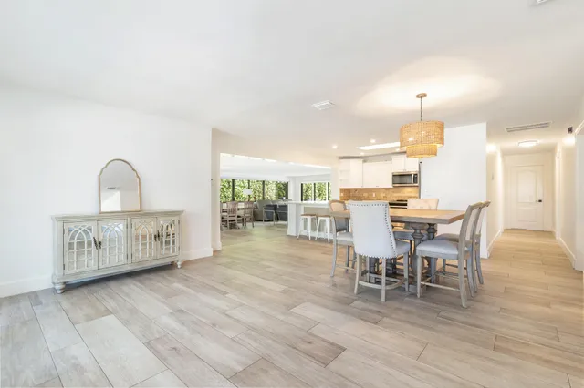 a kitchen with a dining table chairs and white appliances