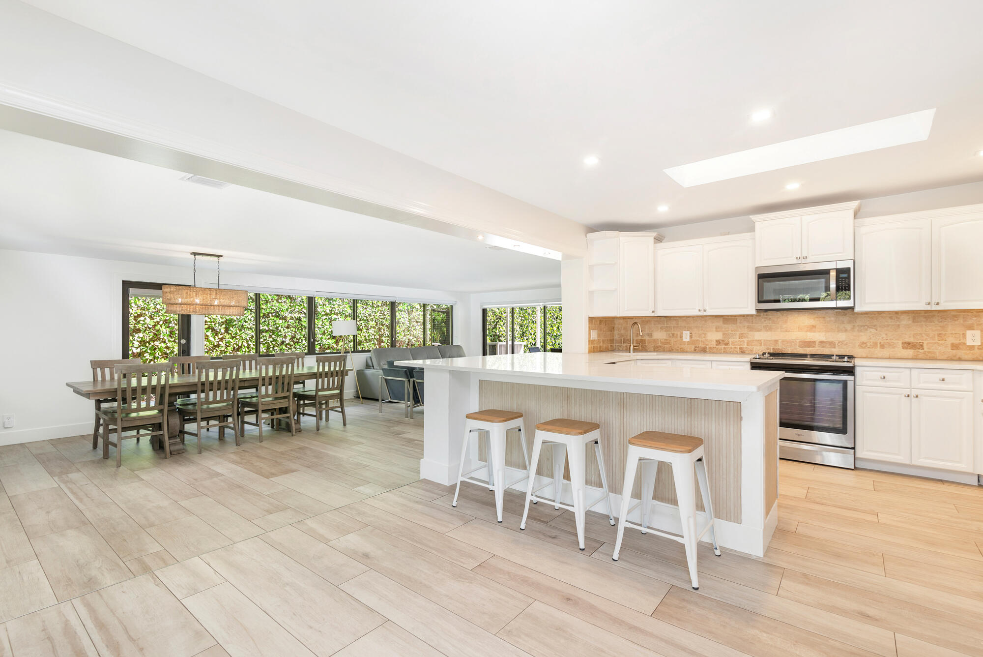 7730 Beta Circle Lake Clarke Shores, FL 33406 - Photo 32 of 50 a kitchen with a dining table chairs and white appliances