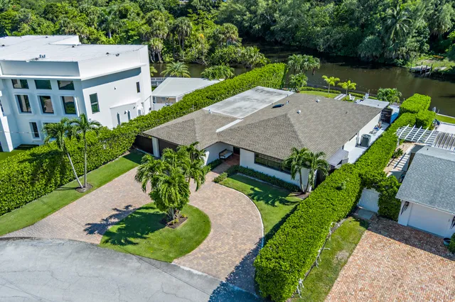 an aerial view of a house with a garden and lake view