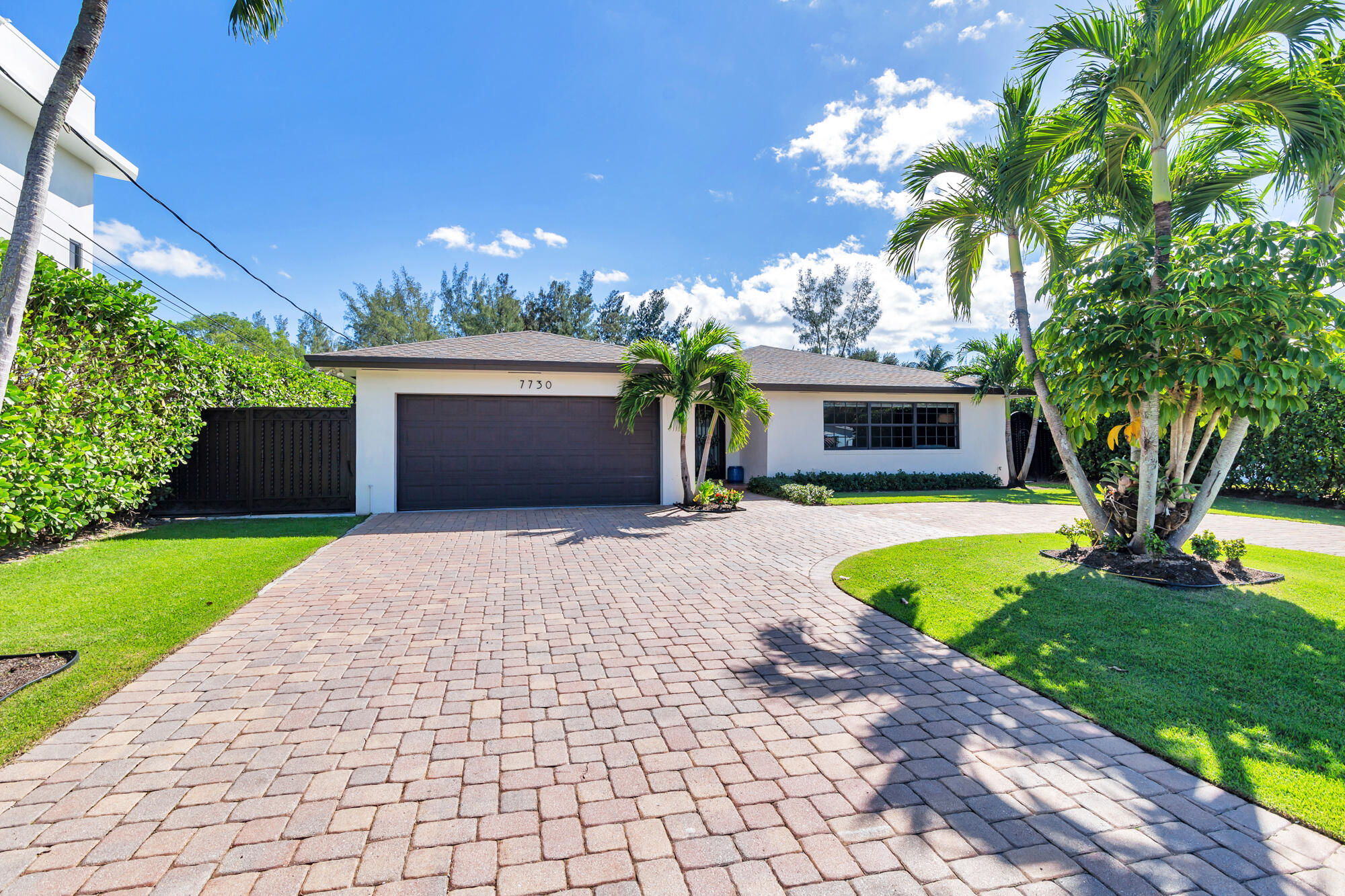 7730 Beta Circle Lake Clarke Shores, FL 33406 - Photo 9 of 50 a front view of a house with a garden and a yard