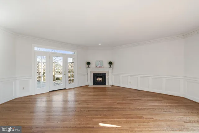 a view of a livingroom with wooden floor and a fireplace