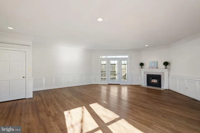 wooden floor fireplace and windows in an empty room