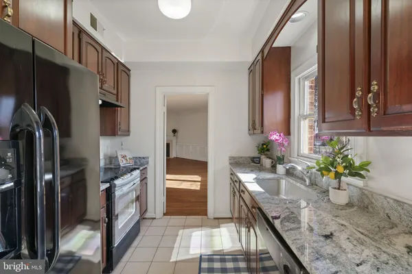 a kitchen with stainless steel appliances granite countertop a sink a stove and a refrigerator