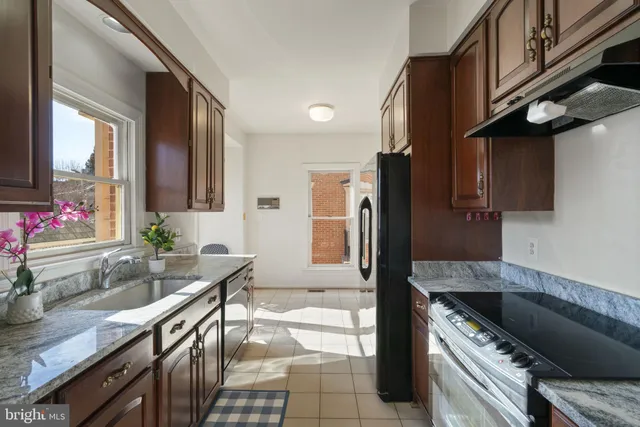 a kitchen with granite countertop a sink stainless steel appliances a counter space and cabinets
