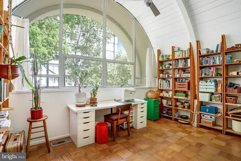 a view of a workspace with furniture and a large window