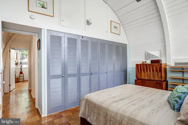 a bedroom with a bed and wooden floor