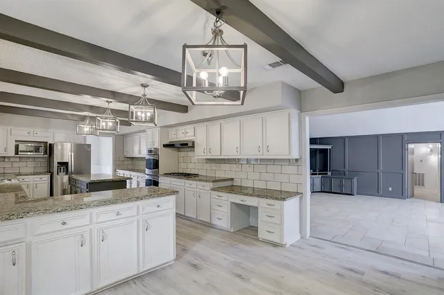 a kitchen with stainless steel appliances granite countertop a sink and cabinets