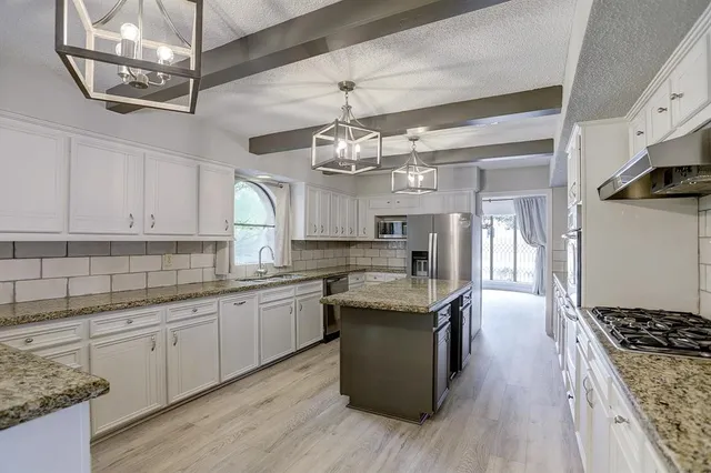 a kitchen with stainless steel appliances granite countertop a sink and stove